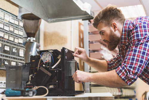 Kundendienstmonteur repariert Kaffeemaschine